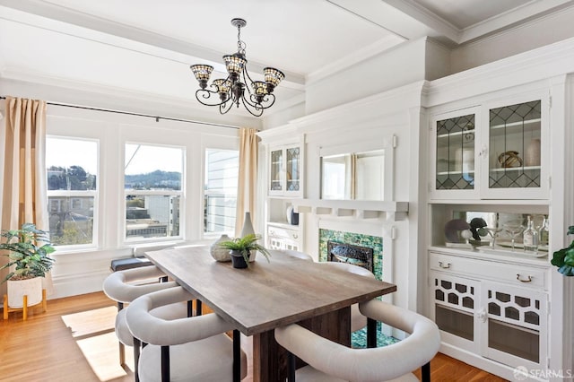 dining room with a chandelier, light hardwood / wood-style flooring, and crown molding