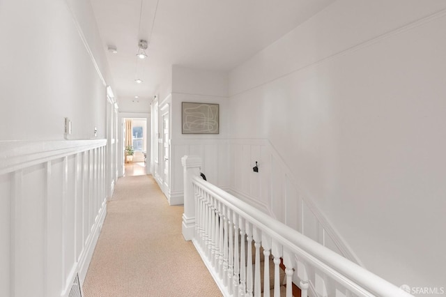 hall with ornamental molding and light carpet