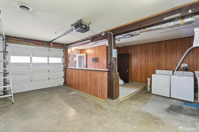 garage with wooden walls, washer and dryer, and a garage door opener