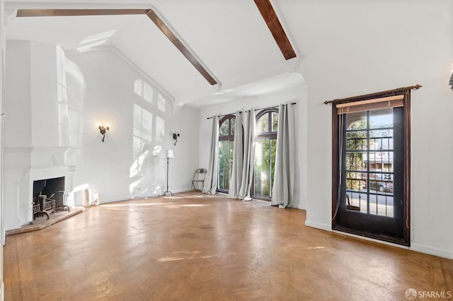 unfurnished living room with a fireplace, beam ceiling, high vaulted ceiling, and plenty of natural light