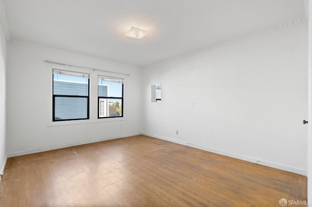 spare room featuring hardwood / wood-style flooring and crown molding