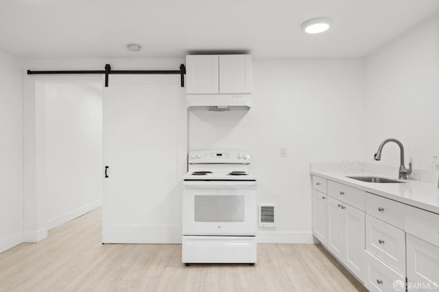 kitchen featuring white electric range oven, a barn door, white cabinetry, and sink