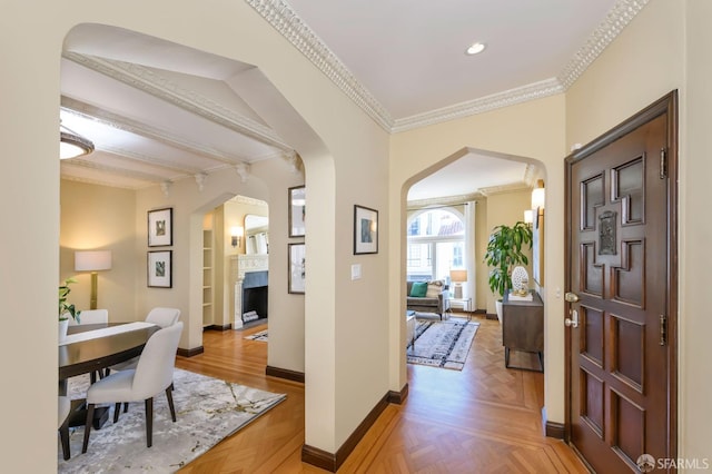 hallway with arched walkways, ornamental molding, recessed lighting, and baseboards