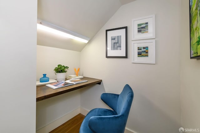 office area with dark wood-type flooring, lofted ceiling, and baseboards