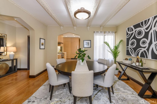 dining space with arched walkways, beam ceiling, baseboards, and parquet flooring