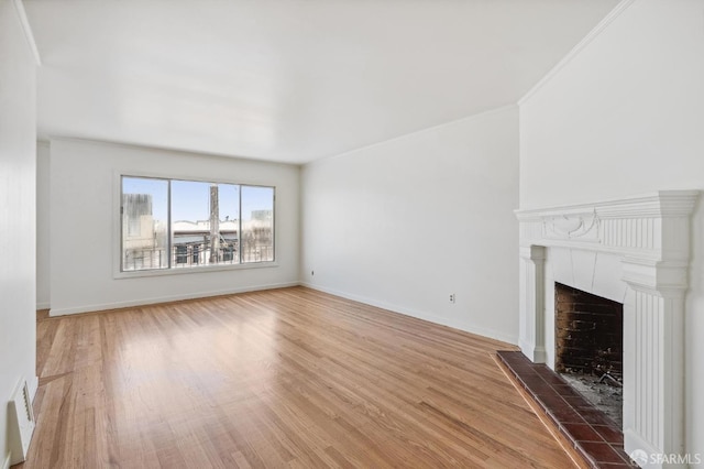 unfurnished living room with hardwood / wood-style floors, crown molding, and a fireplace