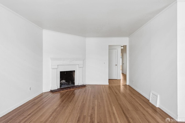 unfurnished living room with ornamental molding and light hardwood / wood-style flooring