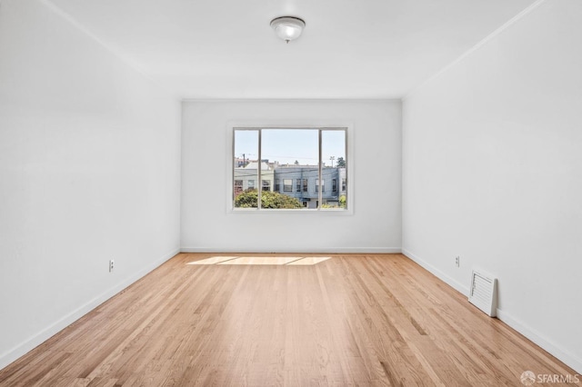 empty room featuring crown molding and light hardwood / wood-style flooring