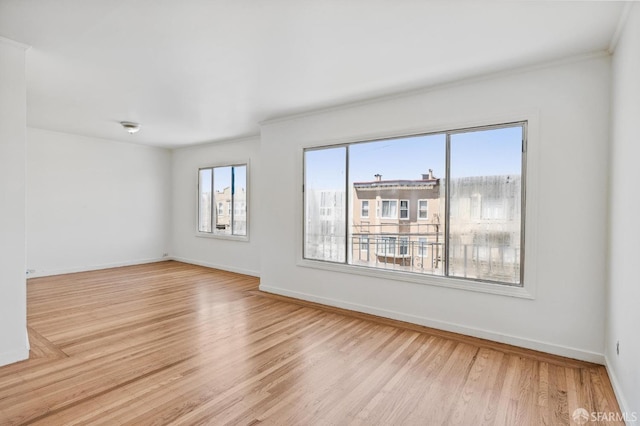 unfurnished room featuring light wood-type flooring and ornamental molding