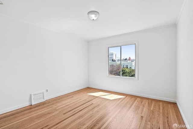 spare room featuring light hardwood / wood-style floors and crown molding