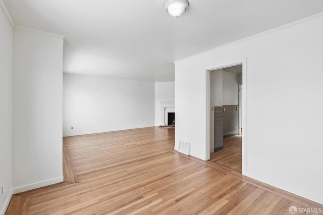 unfurnished living room featuring crown molding and light hardwood / wood-style floors