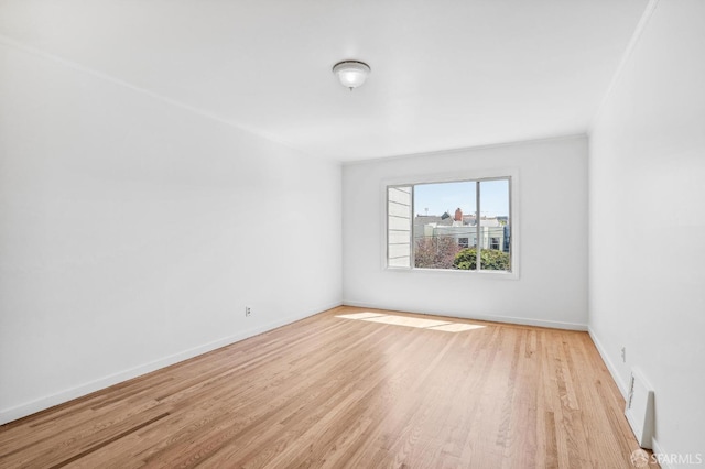 unfurnished room featuring crown molding and light wood-type flooring