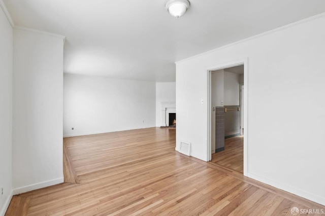 unfurnished room with ornamental molding and light hardwood / wood-style flooring