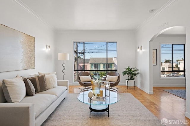 living area with crown molding, baseboards, and arched walkways