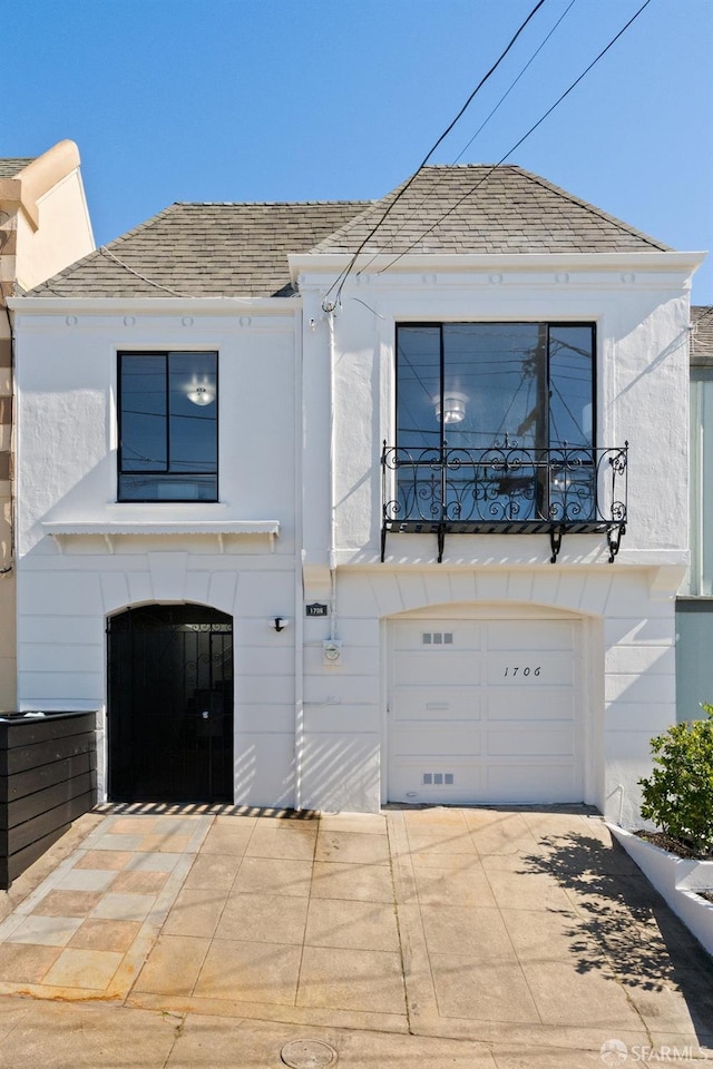 view of front of home with a garage, concrete driveway, roof with shingles, and stucco siding