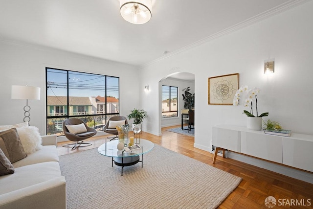 living room featuring crown molding, baseboards, and arched walkways