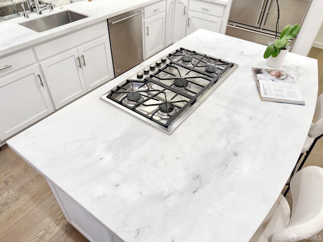 16 Barneson Ave, San Mateo, CA 94402 - kitchen featuring a sink, appliances with stainless steel finishes, white cabinetry, wood finished floors, and light stone countertops