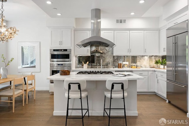 16 Barneson Ave, San Mateo, CA 94402 - kitchen featuring appliances with stainless steel finishes, island exhaust hood, a kitchen island, decorative backsplash, and light countertops