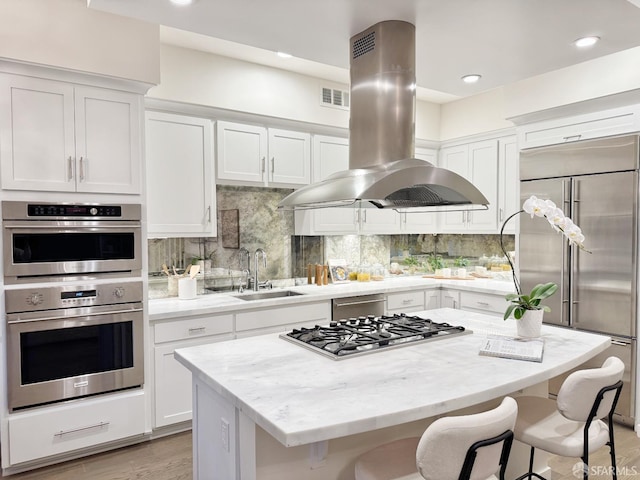 16 Barneson Ave, San Mateo, CA 94402 - kitchen featuring island exhaust hood, appliances with stainless steel finishes, a sink, a breakfast bar area, and recessed lighting