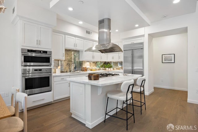 16 Barneson Ave, San Mateo, CA 94402 - kitchen with island exhaust hood, appliances with stainless steel finishes, decorative backsplash, white cabinetry, and a kitchen island