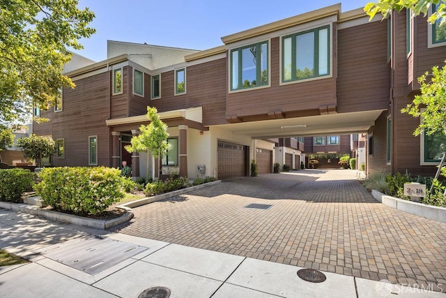 16 Barneson Ave, San Mateo, CA 94402 - view of front facade with decorative driveway, an attached garage, and stucco siding