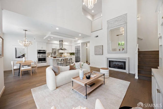 16 Barneson Ave, San Mateo, CA 94402 - living area featuring a chandelier, wood finished floors, a glass covered fireplace, baseboards, and a high ceiling