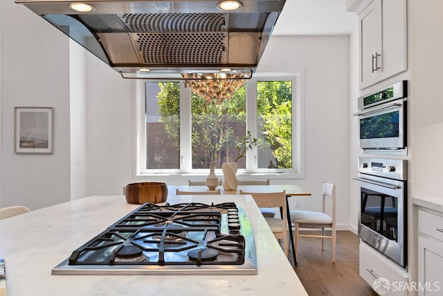 16 Barneson Ave, San Mateo, CA 94402 - kitchen with appliances with stainless steel finishes, range hood, wood finished floors, white cabinetry, and a chandelier