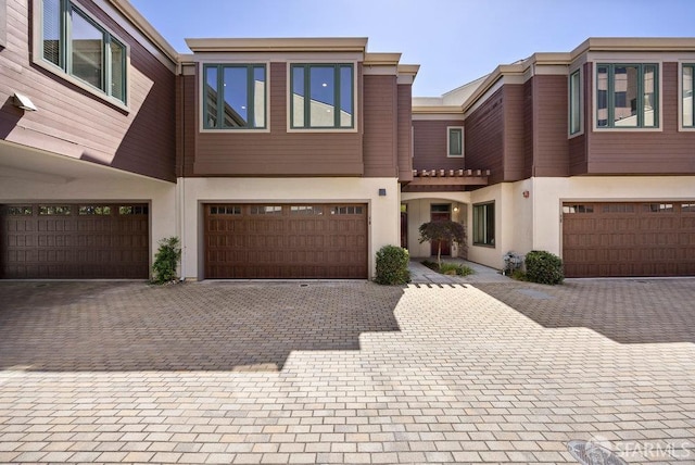16 Barneson Ave, San Mateo, CA 94402 - view of property featuring stucco siding, a garage, and driveway
