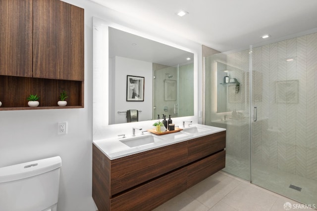 bathroom with tile patterned floors, a shower with door, vanity, and toilet