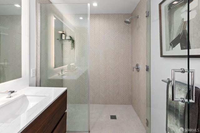 bathroom with vanity and a tile shower