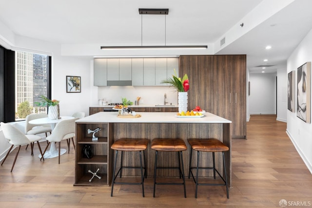 kitchen featuring a kitchen breakfast bar, light hardwood / wood-style floors, and a kitchen island