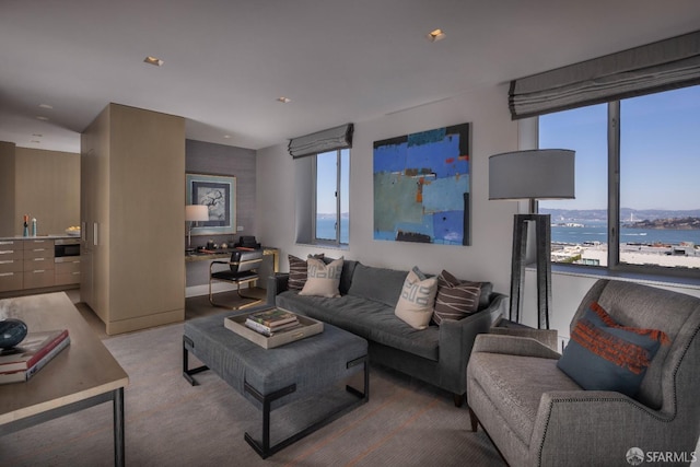 living room with light colored carpet and a water view