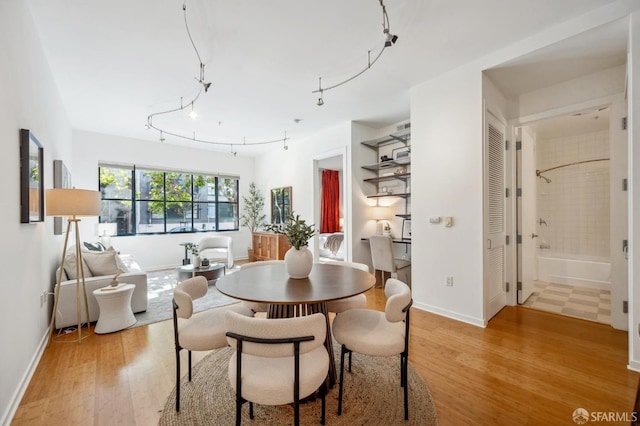 dining area featuring light wood-style floors and baseboards