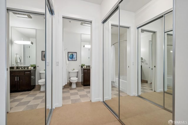 bathroom with a shower with shower curtain, vanity, toilet, and tile patterned floors