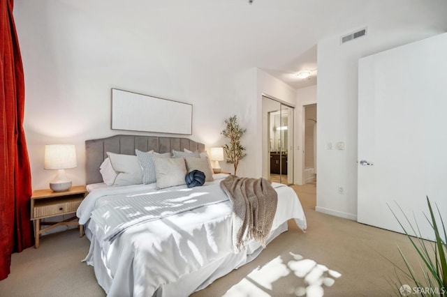 bedroom featuring connected bathroom, carpet floors, visible vents, baseboards, and a closet