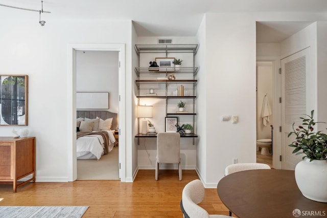 office featuring wood finished floors, visible vents, and baseboards