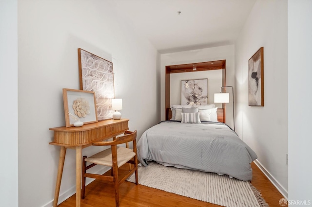 bedroom with wood finished floors and baseboards