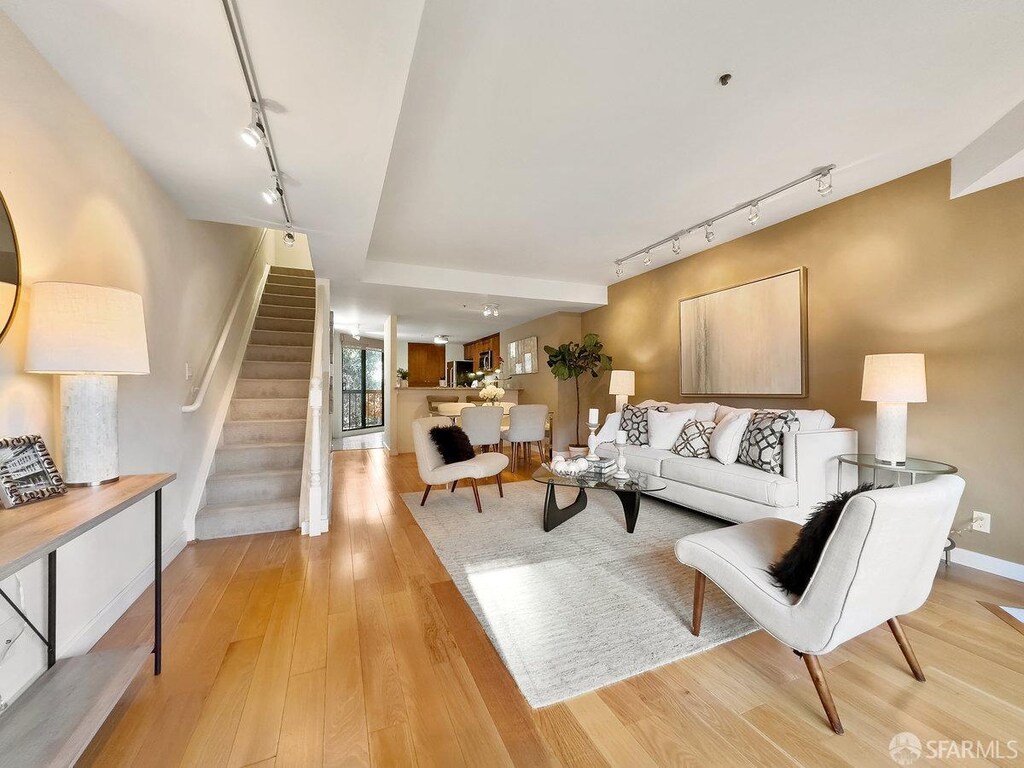 living room with light hardwood / wood-style floors and rail lighting