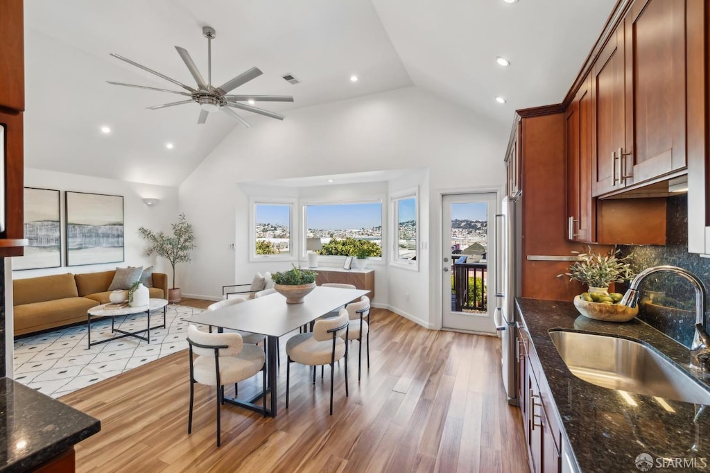 dining area with lofted ceiling, light wood-type flooring, ceiling fan, and sink