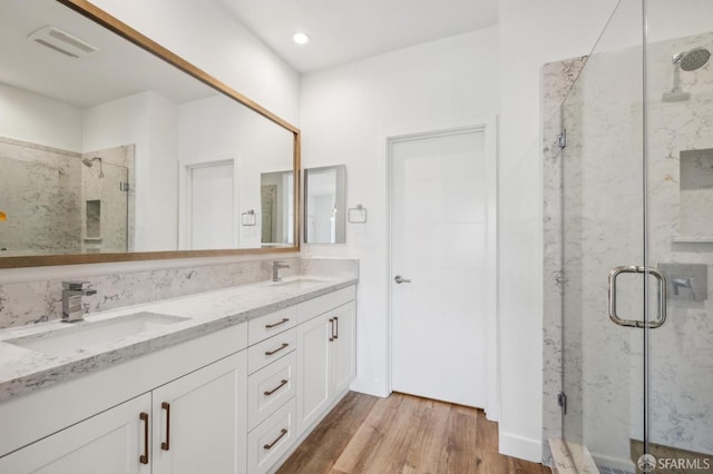 3821 Wattling St, Oakland, CA 94601 - bathroom featuring a marble finish shower, wood finished floors, double vanity, and recessed lighting
