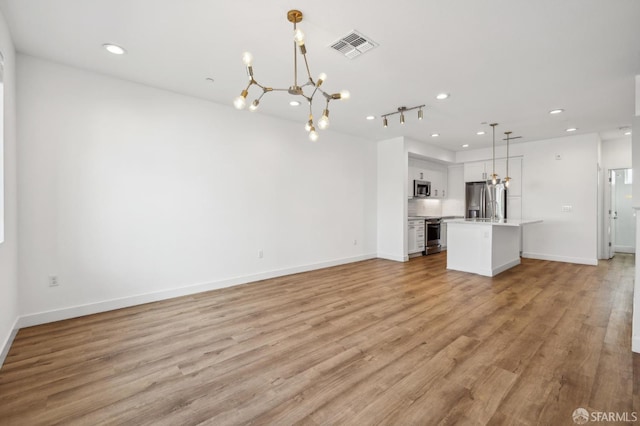 3821 Wattling St, Oakland, CA 94601 - unfurnished living room with a chandelier, recessed lighting, light wood finished floors, and baseboards