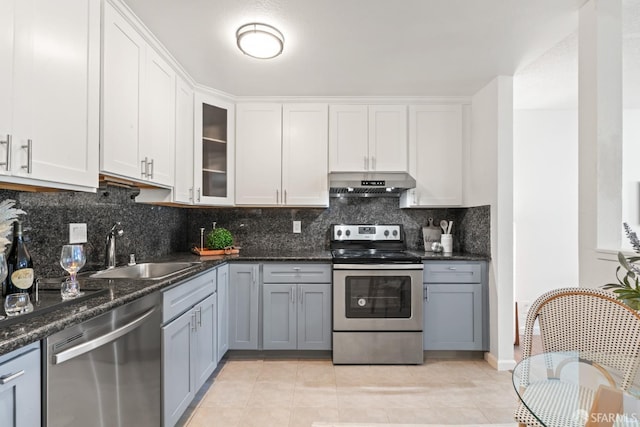 kitchen with extractor fan, sink, white cabinetry, appliances with stainless steel finishes, and light tile patterned floors