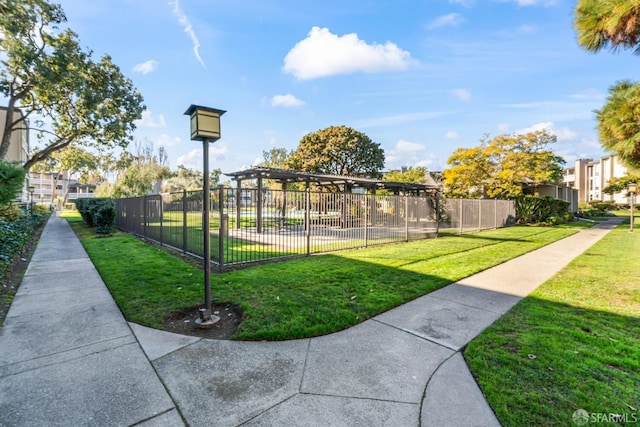 view of property's community with a yard and a pergola