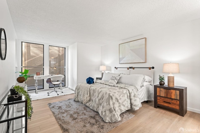 bedroom with a textured ceiling and light hardwood / wood-style flooring