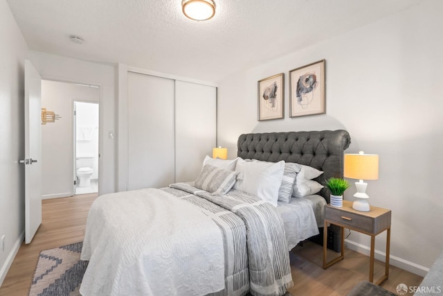 bedroom featuring a closet, a textured ceiling, and wood-type flooring