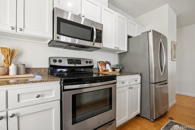 323 29th St Unit C301, San Francisco, CA 94131 - kitchen with appliances with stainless steel finishes, light wood-type flooring, white cabinetry, and dark stone countertops