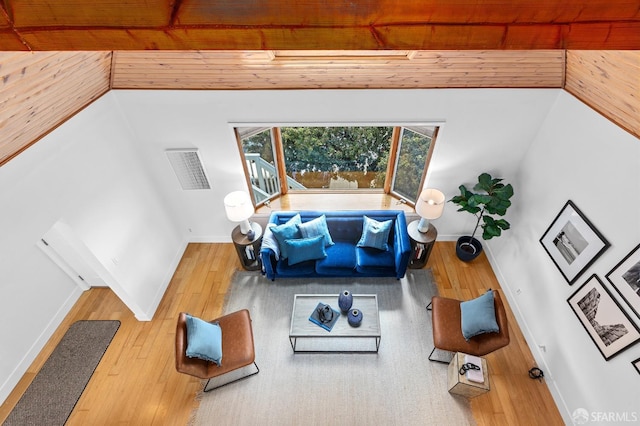 living area with wood ceiling, baseboards, and wood-type flooring