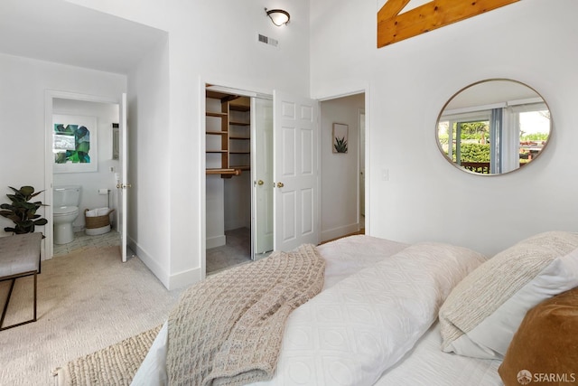 carpeted bedroom featuring a closet, visible vents, connected bathroom, and baseboards