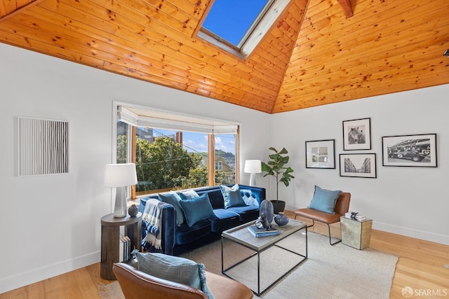 living area with visible vents, baseboards, a skylight, wood finished floors, and high vaulted ceiling