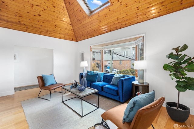 living room featuring a skylight, baseboards, high vaulted ceiling, and wood finished floors